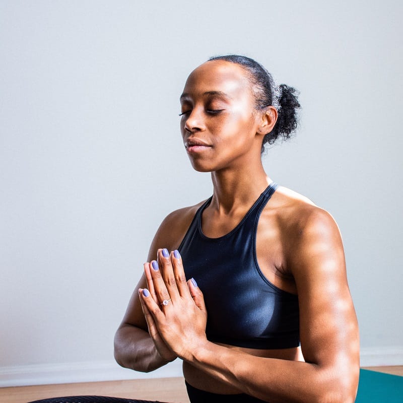 woman meditating with hands in prayer position