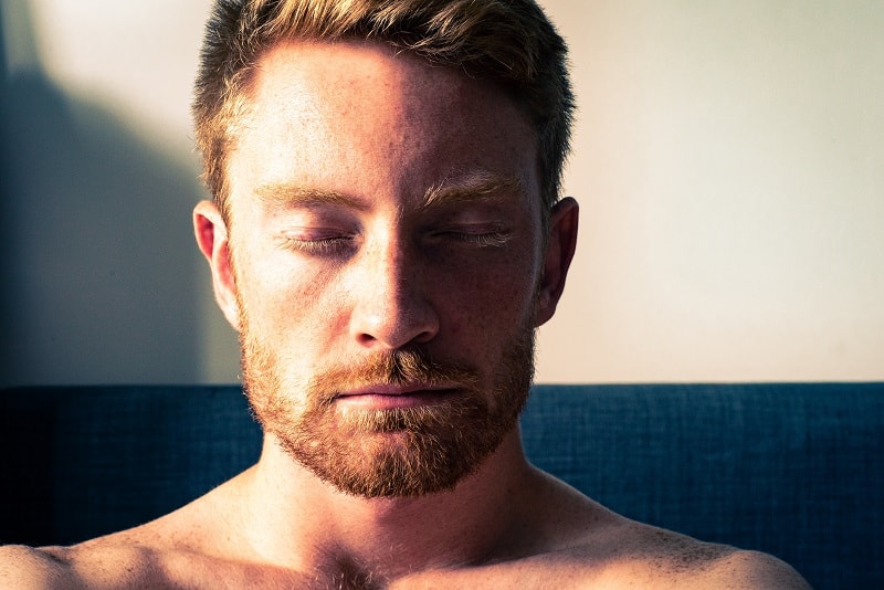 man closing eyes in meditation