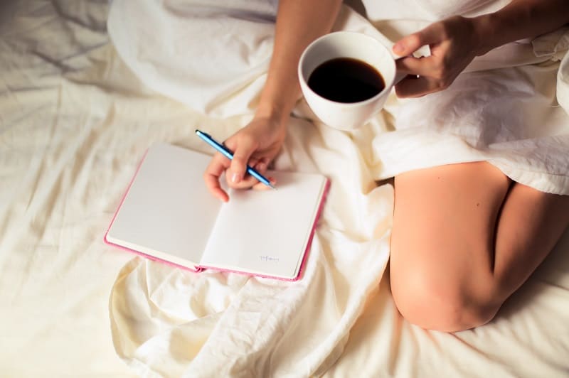 80 Insightful Journal Prompts for Self Discovery and Awareness 3 woman writing in journal with coffee