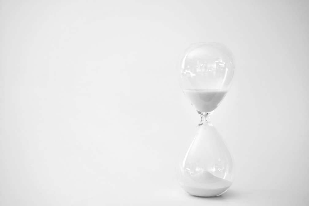 an-hourglass-timer-or-clock-with-sand-in-it-against-a-white-background-sand-running-through-the-bulbs_t20_YwBa2j hourglass timer