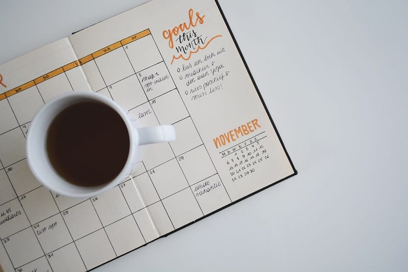 bullet journal planner with mug of coffee