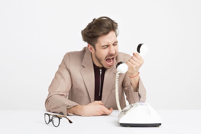 man shouting down telephone
