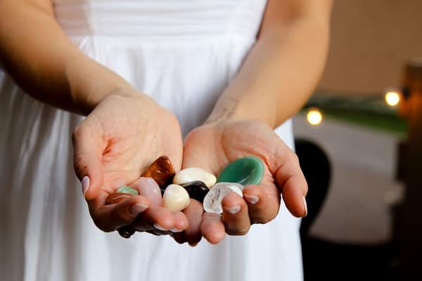 cleansing tarot cards with crystals woman holding crystals