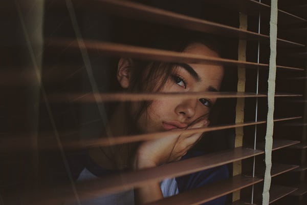 woman looking out of window bored