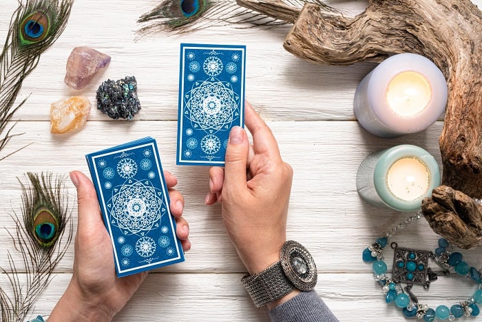 person reading tarot with crystals