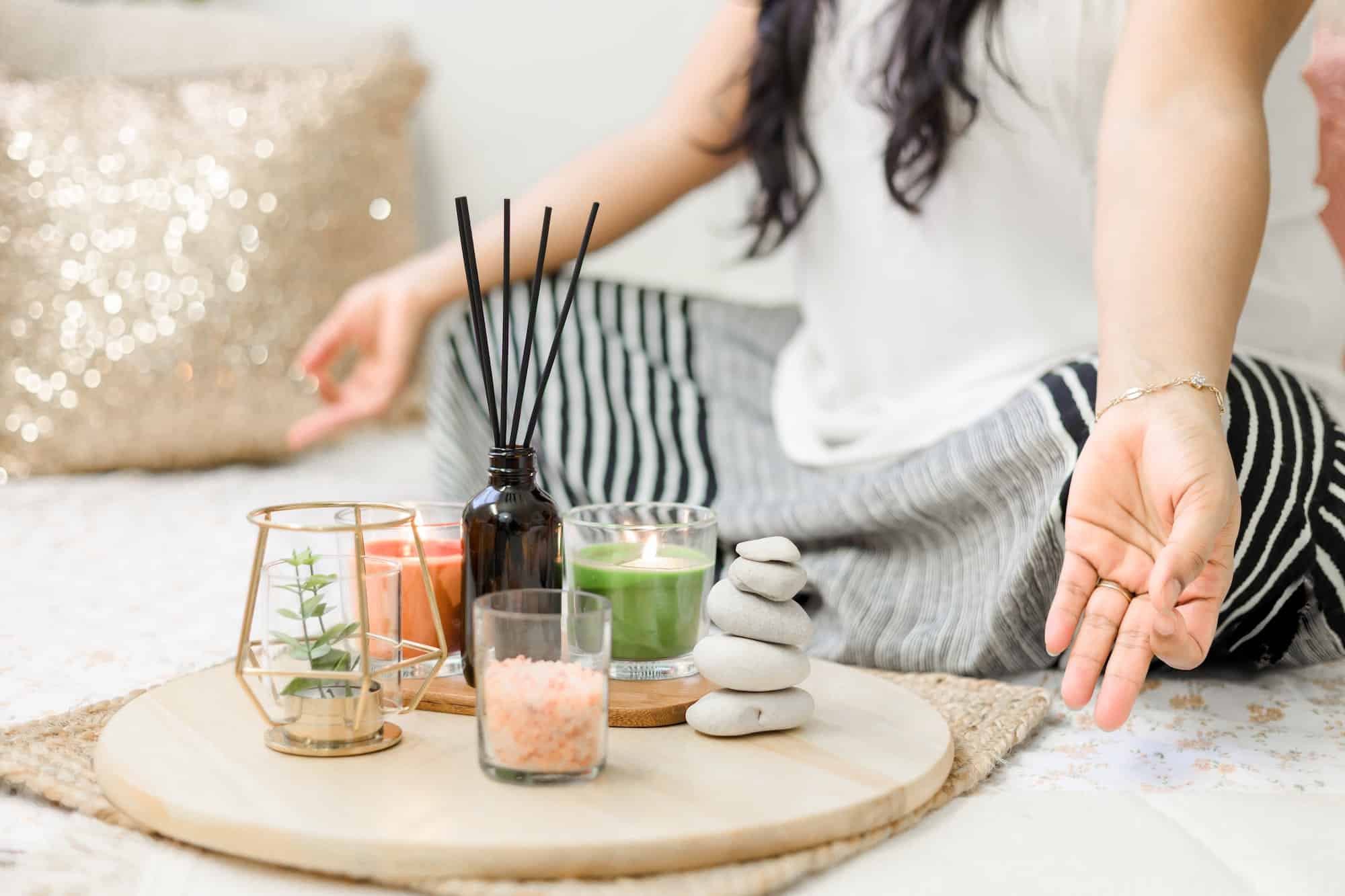 woman meditating with candles and incense