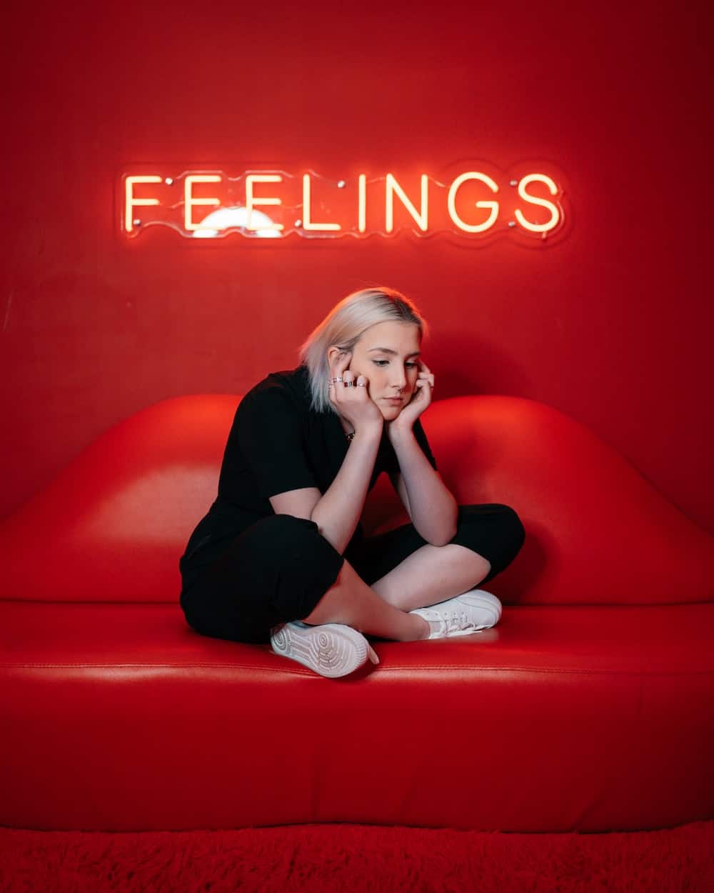 woman looking sad with neon feelings sign
