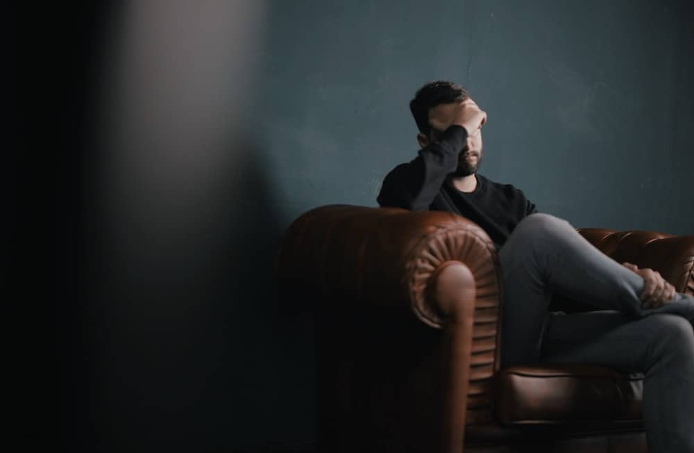 man looking depressed with head in hands