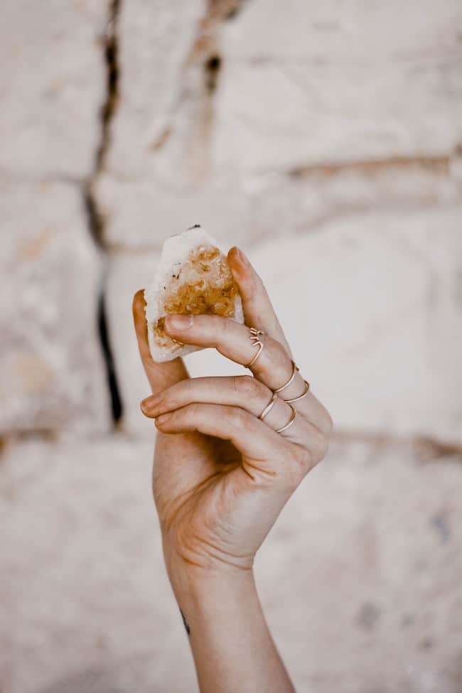 close up of woman's hand holding a raw crystal