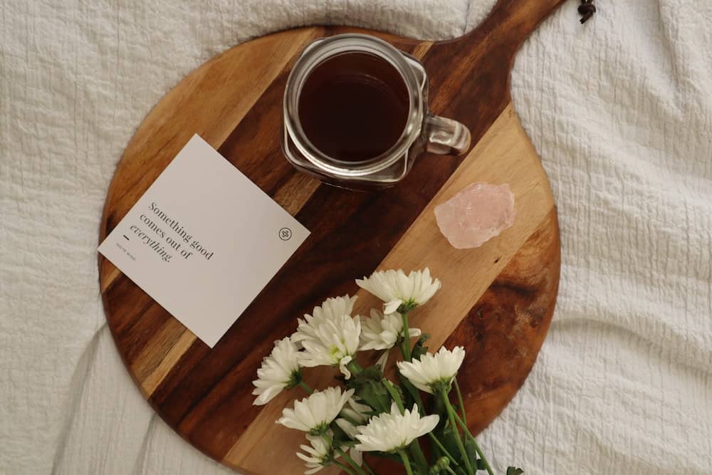 84 Positive Sunday Affirmations to Prepare for the Week Ahead 3 board with coffee, rose quartz crystal, flowers and a note that reads "something good comes out of everything"