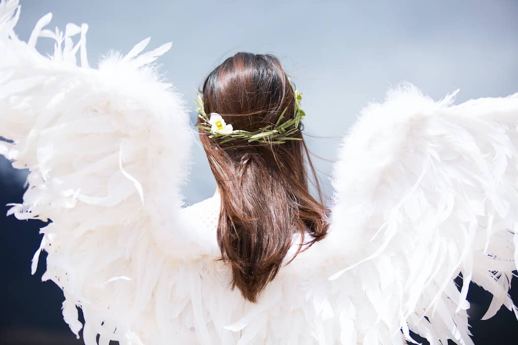 The 14 Best Angel Cards Decks for Healing in 2024 7 back of woman wearing angel wings and flowers in her hair