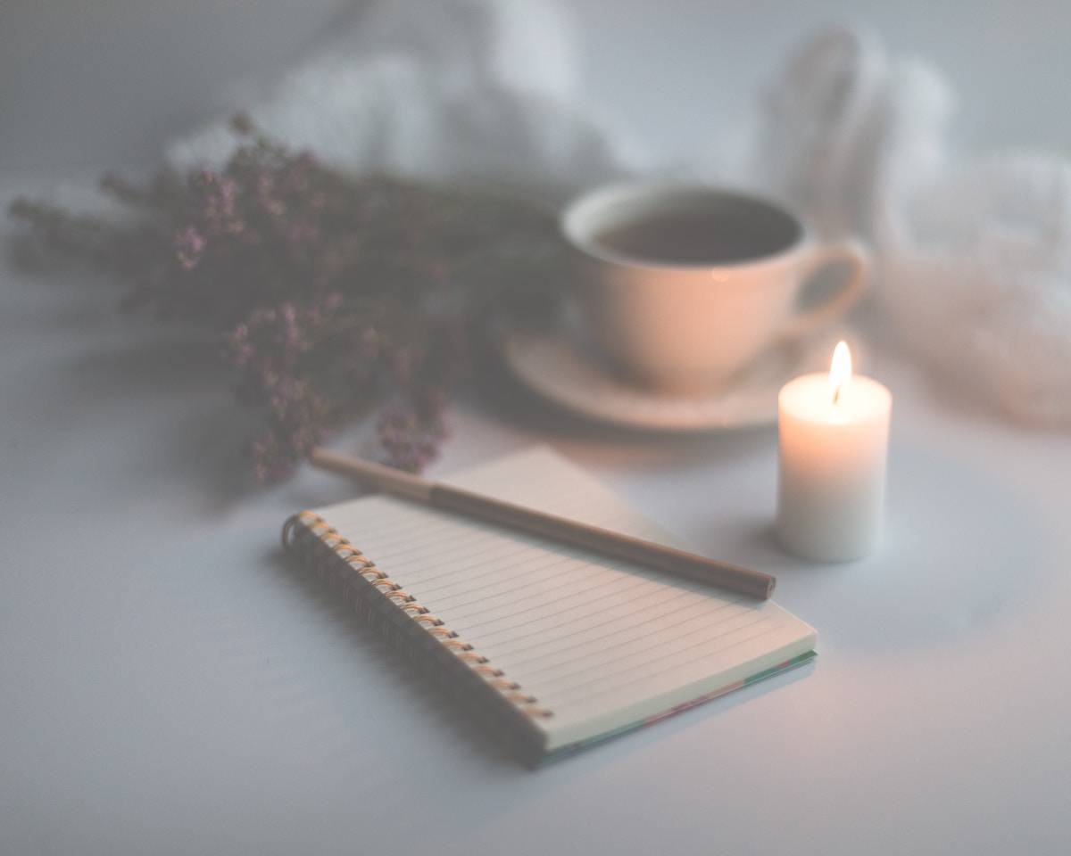 51 Powerful Mindfulness Journal Prompts for Self-Awareness 10 faded image of a journal next to a coffee and candle
