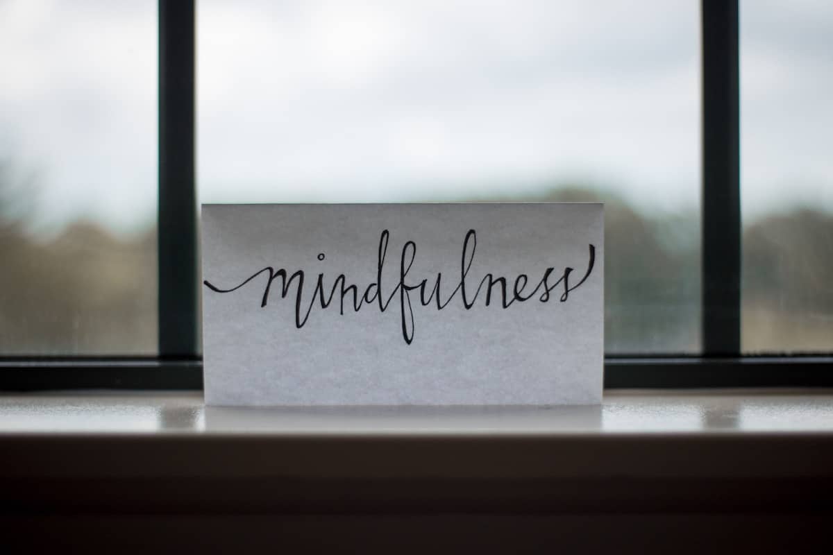 script writing of the word "mindfulness" on a piece of paper against window