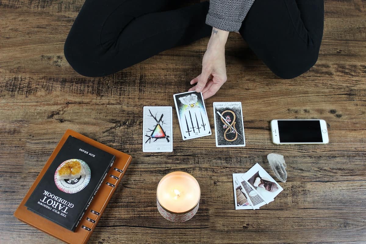 78 Positive Daily Tarot Affirmations for your Deck 6 person sat on floor doing tarot reading with wild unknown tarot deck