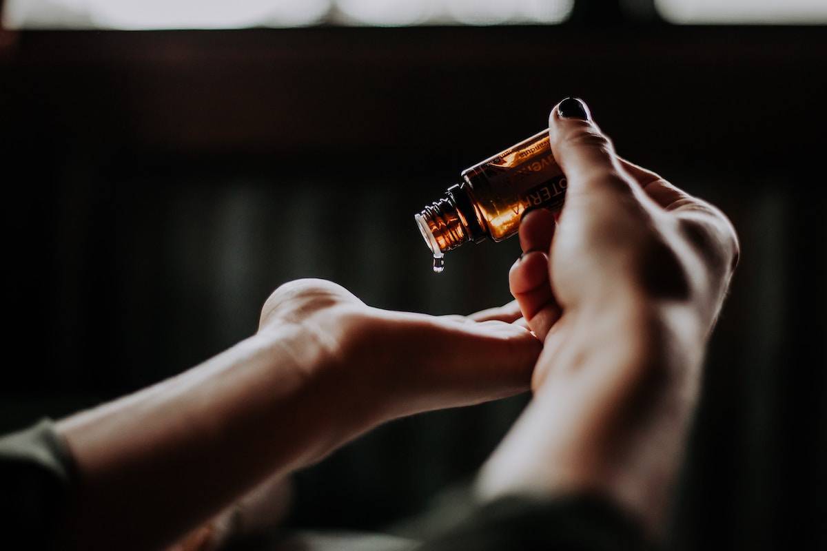 close up of woman's hands pouring essential oil into hand