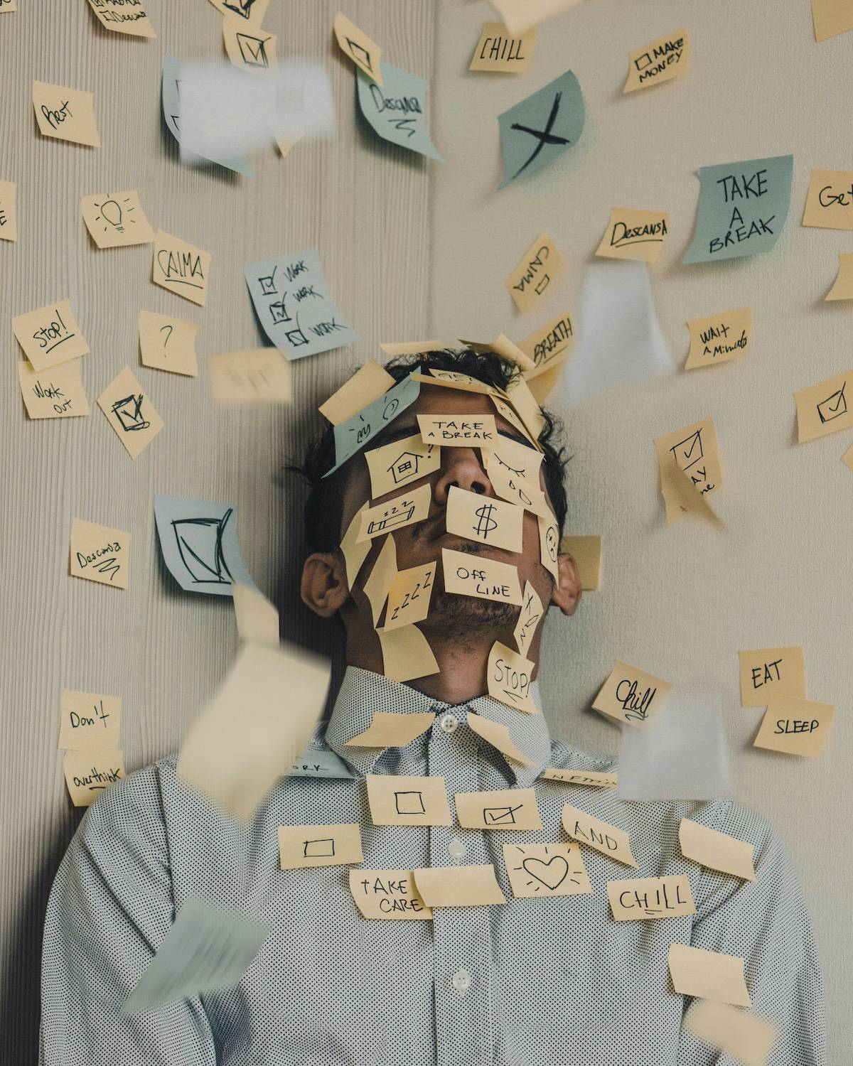 man at work swamped in post it notes feeling stressed