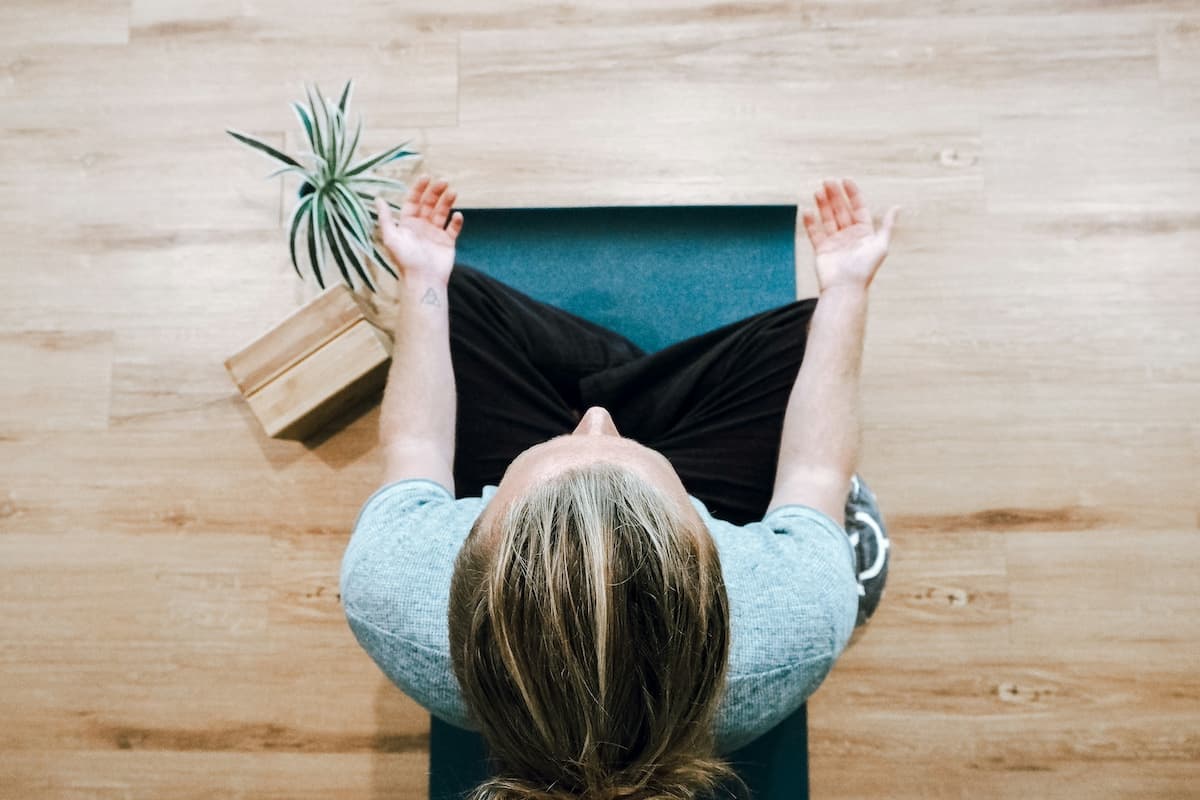 person meditating on yoga mat