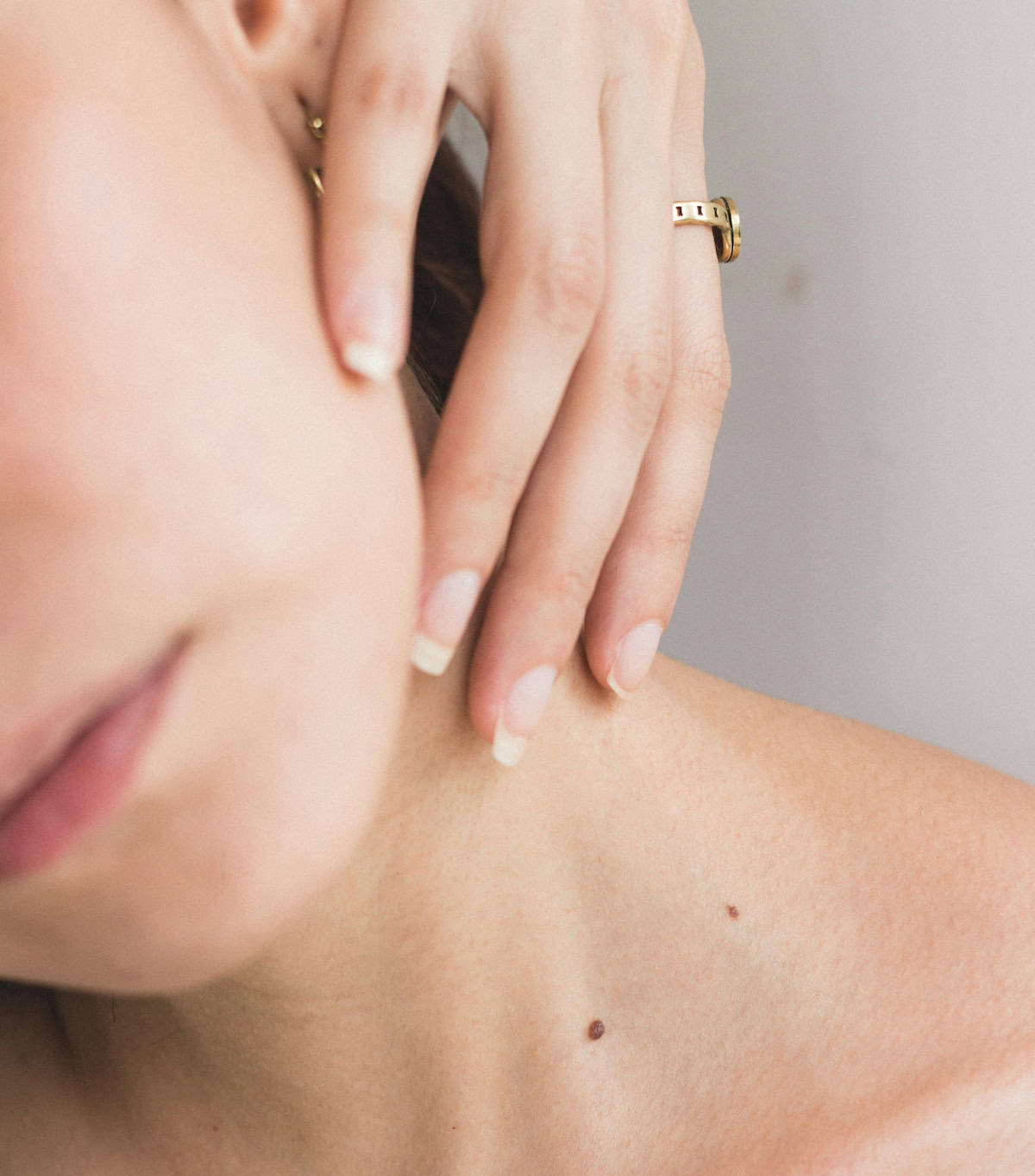 woman softly touching her own neck with healing touch